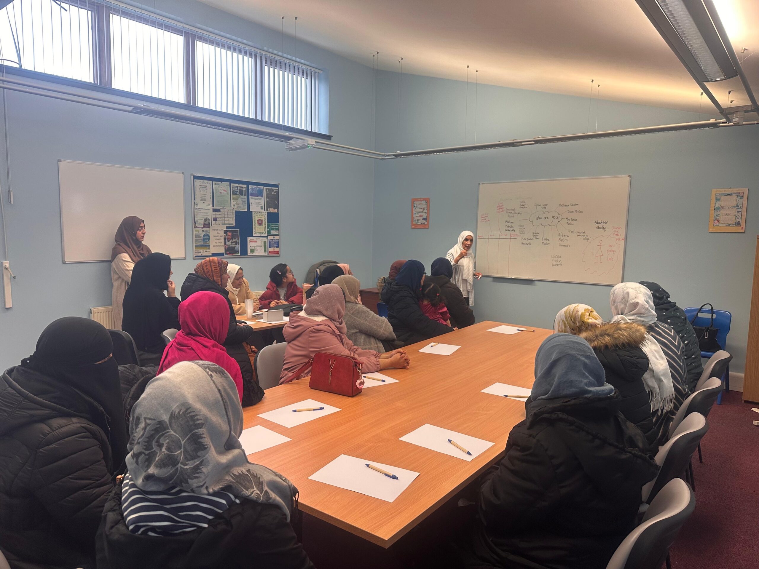 A personal development session with participants around tables at the Chai Centre, Burnley.